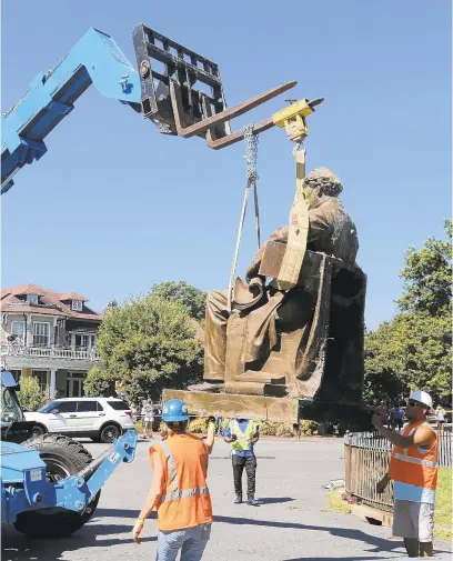  ?? STEVE HELBER/AP ?? Workers remove the statue of Confederat­e Naval officer Matthew Fontaine Maury on Monument Avenue on Thursday in Richmond, Virgina.