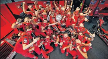  ??  ?? Los miembros de Ducati celebran la victoria de Bagnaia en el garaje del equipo italiano en Alcañiz.