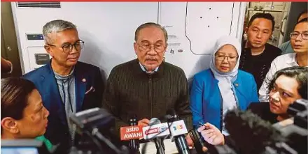  ?? BERNAMA PIC ?? Prime Minister Datuk Seri Anwar Ibrahim speaking to reporters onboard a Malaysia Airlines plane en route to Kuala Lumpur on Monday night.
