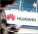  ?? (AP) ?? In this file photo, a woman walks by a Huawei retail store in Beijing. The US government gave chipmakers and technology companies a 90-day extension to sell products to technology giant Huawei.