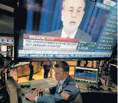  ??  ?? The news conference of Federal Reserve chairman Ben Bernanke appears on a television screen at a trading post on the floor of the New York Stock Exchange on Wednesday.