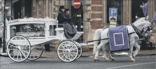  ?? Picture: Getty ?? White horses with purple plumes and ensigns pull the white funeral coach containing Christina Edkins’s silver casket