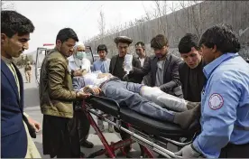  ?? TAMANA SARWARY / ASSOCIATED PRESS ?? An injured man is carried into an ambulance after an attack in Kabul, Afghanista­n, on Friday. Gunmen attacked a remembranc­e ceremony for a minority Shiite leader, killing 32 people and wounding dozens more, officials said.