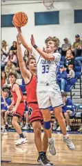  ?? Courtney Couey, Ringgold Tiger Shots ?? Ringgold’s Luke Rominger puts up a shot around Heritage’s Bryce Travillian this past Saturday. The Tigers scored 26 points in the fourth quarter, but still fell six points short on the final scoreboard as the Generals earned a 60-54 win.