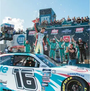  ?? MIKE CAUDILL /AP ?? Chandler Smith, center, stands on his car as he celebrates with his team after winning the NASCAR Xfinity Series race Saturday at Richmond Raceway.