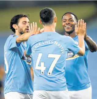  ?? AP ?? Manchester City’s Phil Foden (centre) celebrates with Raheem Sterling (right) after scoring his side’s third goal during the English Premier League match between Manchester City and Arsenal at the Etihad Stadium in Manchester, England, yesterday. The English Premier League resumed after its three-month suspension because of the coronaviru­s outbreak.