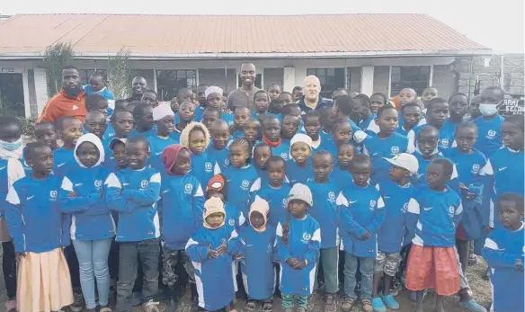  ?? ?? Gary Lamb pictured with locals in Keroche in their donated shirts.