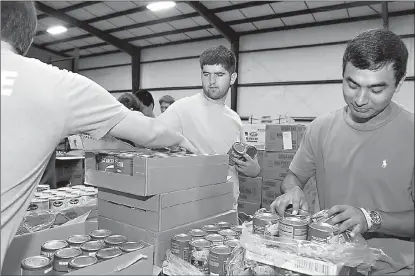  ?? Staff photo by Jerry Habraken ?? Texas High AP English students Josh Whitehorn, center, and Luis Moreno help pack boxes of food Tuesday morning while volunteeri­ng at Harvest Texarkana after the class made a donation of $8,900 for Harvest Texarkana’s Backpack program.