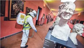  ?? ALESSANDRO PONE/AP ?? A worker sprays disinfecta­nt in the museum hosted by the Maschio Angioino medieval castle in Naples, Italy, Tuesday.