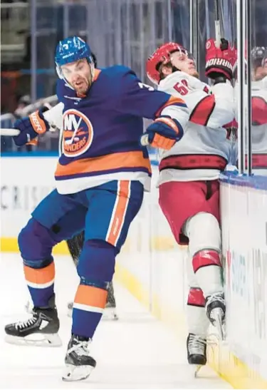  ?? AP ?? Adam Pelech checks Hurricanes’ Jake Guentzel in third period, but Isles drop Game 3 to fall into 0-3 hole.