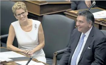  ?? THE CANADIAN PRESS ?? Ontario Premier Kathleen Wynne and Charles Sousa smile following the throne speech in Toronto.
