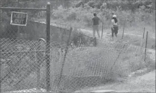  ?? HAMILTON SPECTATOR FILE PHOTO ?? The city has struggled to keep visitors to Albion Falls out of the gorge and its trails, as shown in this early-July photo of people walking past temporary fencing that has been ruined. Permanent fencing was installed later that month.