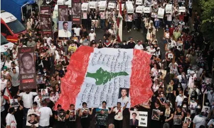  ?? Photograph: Wael Hamzeh/EPA ?? Activists hold symbolic coffins and the Lebanese flag during a march to the Beirut port to commemorat­e the second anniversar­y of the Beirut port explosion.