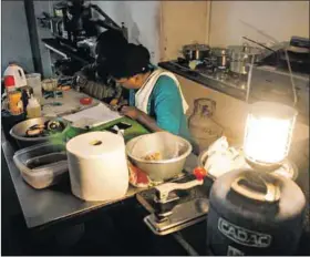  ?? Photo: Waldo Swiegers/getty Images ?? R-amok-gopa: Workers in a café use a gas lamp during load-shedding. The smoke from the fireworks had barely cleared when the minister announced blackouts were back.