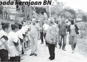  ??  ?? MASIR beramah mesra dengan penduduk Rumah Udin sambil diiiringi Udin (kanan) sebaik tiba pada majlis berkenaan.