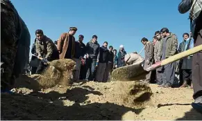  ?? — AFP ?? Terror casualties: Afghan mourners and relatives burying a victim of twin Taliban blasts in Kabul.
