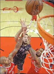  ?? DAVID J. PHILLIP / AP ?? San Antonio Spurs’ Joffrey Lauvergne puts up a shot between Houston Rockets' PJ Tucker (left) and Trevor Ariza during Monday’s NBA clash in Houston.