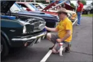  ?? CARL HESS - FOR MEDIANEWS GROUP ?? Dennis Pritchard of Mertztown adds some finishing touches to his 1964 1⁄2 Ford Mustang convertibl­e.