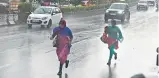  ?? —R. PAVAN ?? People run for shelter as sudden rain hits Jubilee Hills, Hyderabad on Saturday.