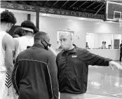  ?? BUDDY COLLINGS/ORLANDO SENTINEL ?? Tim Thomas, right, converses with another Orlando Christian Prep assistant coach, Markel Morgan, during a region playoff game. Thomas, a former UCF assistant, is in his fifth year on the OCP staff.