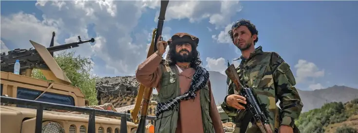  ?? ?? Afghan armed men supporting the Afghan security forces against the Taliban stand with their weapons and Humvee vehicles in Panjshir province