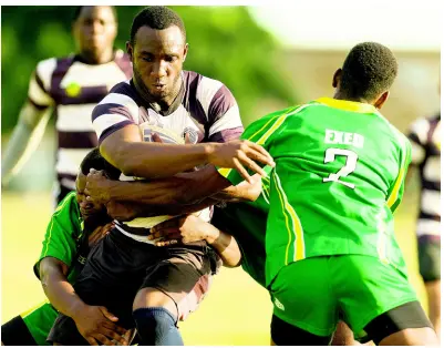  ?? GLADSTONE TAYLOR/MULTIMEDIA PHOTO EDITOR ?? Devar Clayton (centre) of G.C. Foster clutches the ball as he is tackled by EXED players during the Intercol Rugby League match played at Excelsior Community College in Kingston on Saturday, February 2. The game ended with a score of 36 points to 28 in Excelsior’s favour.