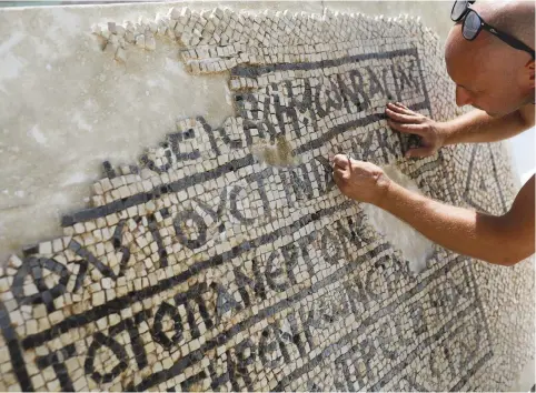  ?? (Reuters) ?? A CONSERVATI­ONIST works at the Rockefelle­r Museum in Jerusalem on a 1,500-year-old mosaic floor bearing a Greek writing, discovered near Damascus Gate in Jerusalem’s Old City.