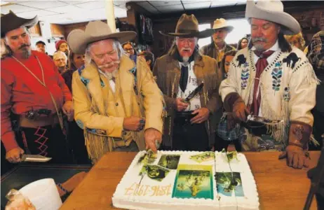  ??  ?? Buffalo Bill re-enactor Buzz Baker cuts the Western hero’s birthday cake Sunday in Golden. From left, the other Buffalo Bill re-enactors at the Buffalo Bill Museum and Grave are Jason Baker, Stanley Beug and R.D. Melfi. William Frederick “Buffalo Bill”...