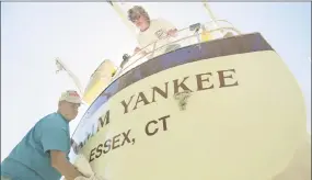  ?? Middletown Press file photo ?? Kay Jacobs, of Waterbury, keeps an eye on husband Bob as he waxes the topsides of their boat, Damm Yankee, at Portland’s Yankee Boat Yard.