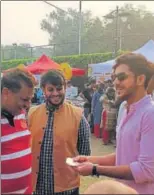  ??  ?? Mentalist Neel Madhav (R) shows a card trick to visitors