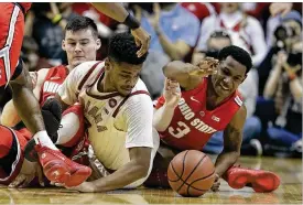  ?? DARRON CUMMINGS / AP ?? Ohio State’s C.J. Jackson reaches for a loose ball Sunday during an on-court free-for-all. After beating the host Hoosiers last season with a 3-pointer in overtime, Jackson sank a game-tying 3 on Sunday and had an assist on the game-winning dunk.