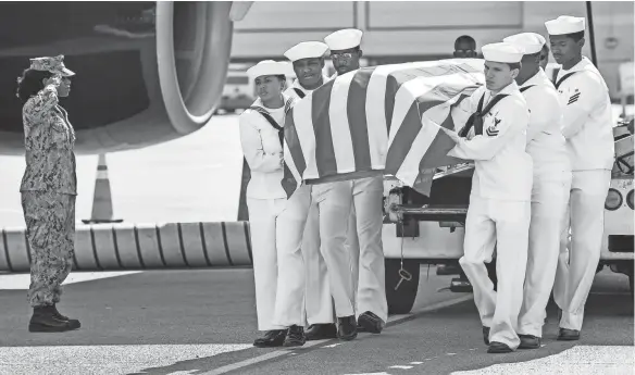  ??  ?? The U.S. Navy Honors Team from detail Navy Operation Support Center Nashville carries the remains of Harold DeMoss, a pilot shot down during WWII, off the plane at the Nashville Internatio­nal Airport in Nashville on Wednesday. LACY ATKINS / THE TENNESSEAN