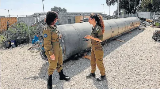  ?? GIL COHEN-MAGEN/AFP ?? Militares israelíes examinan los restos de un misil iraní que cayó sobre la localidad de Kiryat Malachi, en el sur del país.