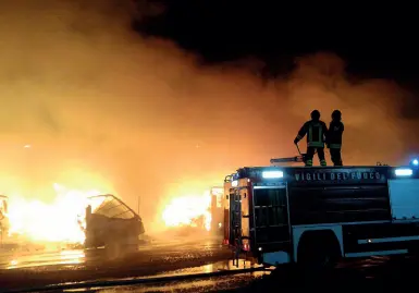  ??  ?? Le fiamme Nella foto a sinistra, i vigili del fuoco all’opera nella notte per spegnere il fuoco nel cortile dell’azienda. A destra, la scena di distruzion­e che si è presentata ieri mattina davanti ai capannoni