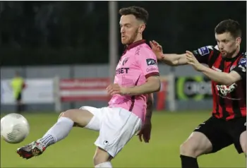  ??  ?? Wexford Youths centre-forward Danny Furlong lays the ball off under pressure from Dan Byrne.