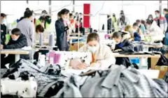  ?? STR/AFP ?? Employees make clothes at a factory of a clothing company in Anlong county, in China’s southweste­rn Guizhou province.