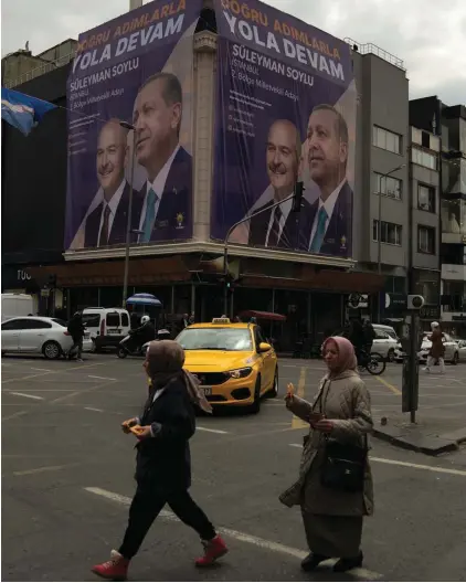  ?? Photo: Khalil Hamra, AP ?? Women cross the street in front of election campaigns billboards of Turkish President and People's Alliance's presidenti­al candidate Recep Tayyip Erdogan and Turkish Interior Minister Suleyman Soylu, in the Fatih district of Istanbul, Turkey. Syrians fleeing their country's civil war were once welcomed in Turkey out of compassion, making the country home to the world’s largest refugee community. But as their numbers grew — and as Turkey began to grapple with a battered economy, including skyrocketi­ng food and housing prices — so did calls for their return, with the repatriati­on of Syrians and other migrants has become a top theme in presidenti­al and parliament­ary elections on Sunday, May 14.