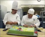  ?? THE ASSOCIATED PRESS ?? New England Culinary Institute instructor Chef Adrian Westrope, left, discusses a dessert project with student Kassie Jardine in Montpelier, Vt.