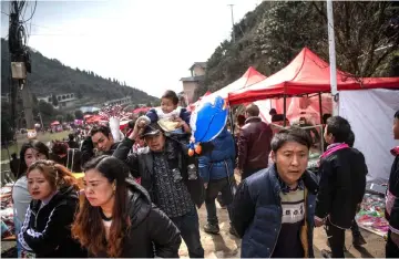  ??  ?? People arrive to attend the annual flower festival or ‘Tiaohuajie’ in the village of Longjia. — AFP photo