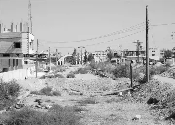  ??  ?? A general view shows a heavily damaged road in the recently retaken desert town of Al-Qaryatain. — AFP photo