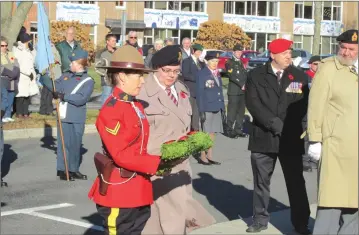  ?? PHOTOS COURTESY OF LOUISE SMITH ?? Members of the RCMP walk alongside people as commemorat­ive wreaths and crosses are laid at the cenotaph.