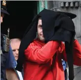  ?? Photos by Michelle Cooper Galvin ?? Hiding from the cameras, Marcus O’Rourke and Brian O’Sullivan, pictured in 2016 leaving a Special Sitting of the District Court in Killarney.