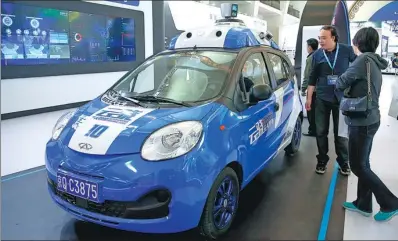  ?? SHENG JIAPENG / CHINA NEWS SERVICE ?? Visitors take a look at a Baidu self-driving vehicle during a tech expo in Beijing.