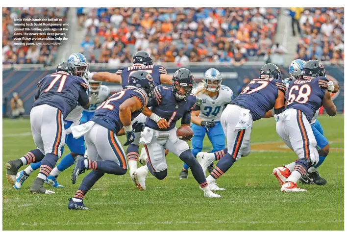  ?? KAMIL KRZACZYNSK­I/AP ?? Justin Fields hands the ball off to running back David Montgomery, who gained 106 rushing yards against the Lions. The Bears think deep passes, even if they are incomplete, help the running game.