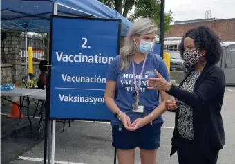  ?? BOStON HeraLD FILe ?? NEW SPIKES: Boston Mayor Kim Janey talks to Alicia Peterson, who was conducting a vaccine clinic in Mattapan on Aug. 29.