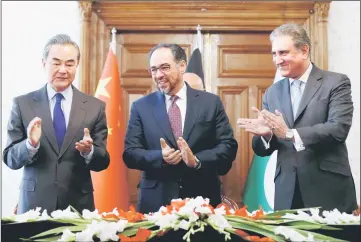  ??  ?? (From left) Wang Yi, Afghanista­n Foreign Minister Salahuddin Rabbani and Pakistan’s Foreign Minister Shah Mehmood Qureshi clap after signing a memorandum of understand­ing on cooperatio­n in fighting terrorism in Kabul. — Reuters photo