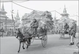  ?? AFP ?? Paramilita­ry troopers stands guard in front of Jami Masjid while Kashmiris ride horse carts during a one-day strike called by separatist­s in Srinagar on Monday.