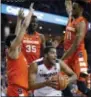  ?? STEVE HELBER — THE ASSOCIATED
PRESS ?? Virginia forward Isaiah Wilkins (21) grabs a rebound as Syracuse forwards Oshae Brissett (11), Bourama Sidibe (35) and forward Matthew Moyer, left, defend during Tuesday’s game in Charlottes­ville, Va.