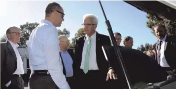  ?? FOTO: DPA ?? Winfried Kretschman­n unterhält sich mit Jens van Eikels, Leiter der Modellreih­e bei Audi, über den neuen Audi e-tron, der vor dem Marriott-Hotel in Santa Clara geparkt ist.