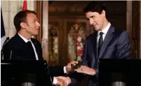  ?? — AFP ?? Emmanuel Macron and Justin Trudeau shake hands during a joint press conference at Parliament in Ottawa on Thursday.